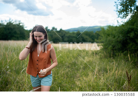 Woman connecting with nature during calming countryside stroll. Woman connecting with nature during calming countryside stroll. 130035588