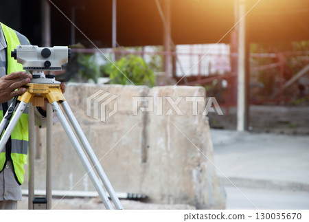 Engineers are adjusting the camera for level measurement in construction work. 130035670