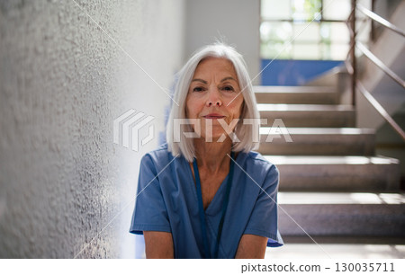 Exhausted nurse resting on stairwell during hospital shift Exhausted nurse resting on stairwell during hospital shift 130035711