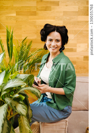 Portrait of woman with hair rollers during slow morning. 130035768