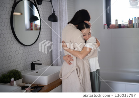 Mom hugging daughter during emotional conversation 130035797