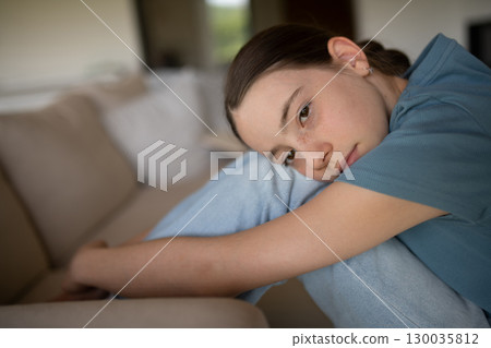 Teenage girl struggling with emotions in living room. 130035812