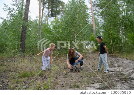 Family Roasting Marshmallows Over Campfire in Forest Family Roasting Marshmallows Over Campfire in Forest 130035950