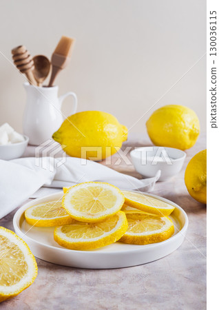 Fresh ripe sliced lemon on a plate on the table, top view 130036115