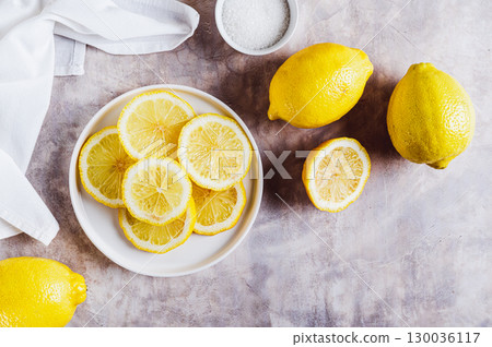 Fresh ripe sliced lemon on a plate on the table top view 130036117