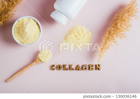 Collagen powder in a bowl and spoon and a glass of water on the table top view 130036146