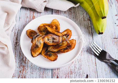 Tajadas fried banana on a plate on the table 130036152