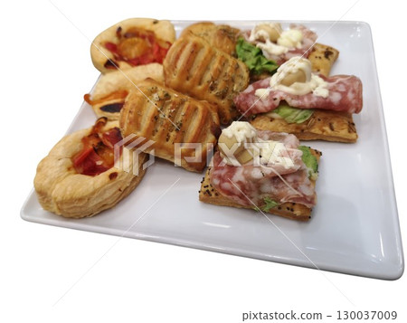 Delicious savory pastries with various toppings on white plate Delicious savory pastries with various toppings on white plate 130037009