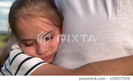 Happy girl hugging her dad, Father's loving embrace, Little girl feels safe, Childhood joy in a hug, Family love outdoors, Warm hugs in nature, Daughter's bright smile, Father and daughter moment 130037048