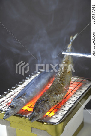 Grilling saury on a charcoal grill with smoke rising Grilling saury on a charcoal grill with smoke rising 130037341