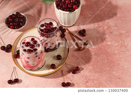 Fruit yogurt with cherries and fresh cow cream for healthy nutrition in a glass on an elegant table. Healthy breakfast with ingredients, kitchen background. Natural food and detox diet concept. 130037400