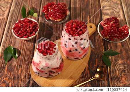 Pomegranate yogurt with berries in a glass on an elegant table, fruit salad, detox diet and natural nutrition concept, healthy breakfast with ingredients.advertisement of a healthy lifestyle Pomegranate yogurt with berries in a glass on an elegant table, fruit salad, detox diet and natural nutrition concept, healthy breakfast with ingredients.advertisement of a healthy lifestyle 130037414