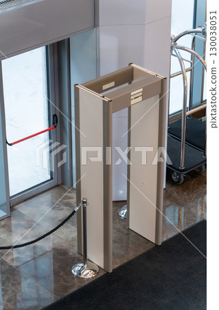 Automatic doors at a modern building entrance with a security metal detector scanner 130038051