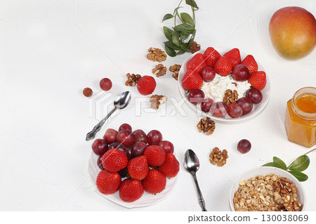 Strawberry yogurt, granola, cottage cheese, fresh berries, mangoes, strawberries and grapes on a light table. The concept of healthy and natural food. Useful breakfast, food for children, selective Strawberry yogurt, granola, cottage cheese, fresh berries, mangoes, strawberries and grapes on a light table. The concept of healthy and natural food. Useful breakfast, food for children, selective 130038069