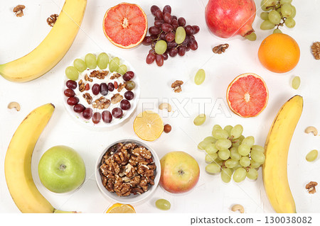 Healthy breakfast, food for children, yogurt with granola, oranges, bananas and grapes on a light table. The concept of a healthy and natural diet, lifestyle. selective focus Healthy breakfast, food for children, yogurt with granola, oranges, bananas and grapes on a light table. The concept of a healthy and natural diet, lifestyle. selective focus 130038082