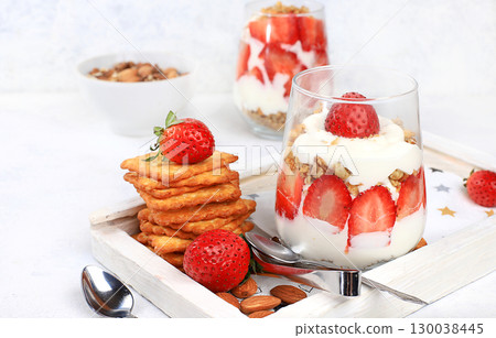 Strawberry yogurt with berries, French cracker and muesli on a bright table, fruit salad. Healthy breakfast with ingredients, natural food concept, lifestyle, food for children, selective focus, place Strawberry yogurt with berries, French cracker and muesli on a bright table, fruit salad. Healthy breakfast with ingredients, natural food concept, lifestyle, food for children, selective focus, place 130038445