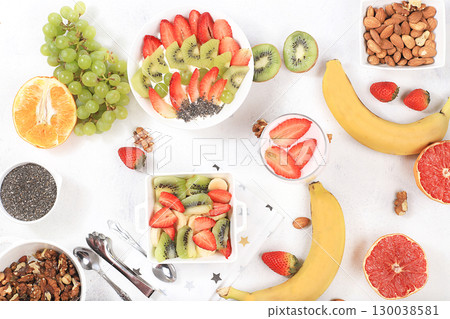 Healthy breakfast with ingredients, fruit salad with strawberries, muesli, grapes, banana and chia seeds for weight loss. The concept of natural nutrition and detox diet, lifestyle, selective focus, Healthy breakfast with ingredients, fruit salad with strawberries, muesli, grapes, banana and chia seeds for weight loss. The concept of natural nutrition and detox diet, lifestyle, selective focus, 130038581