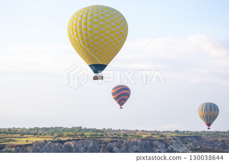 Hot air balloons soaring above the stunning landscapes of Cappadocia, Turkey during sunrise Hot air balloons soaring above the stunning landscapes of Cappadocia, Turkey during sunrise 130038644