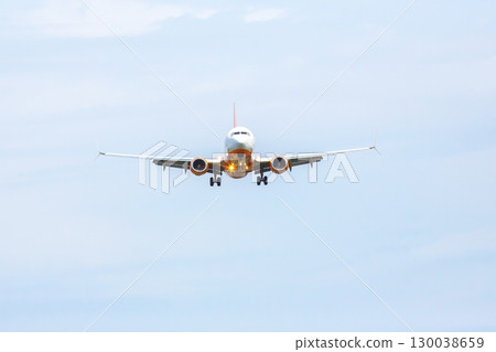 Airplane approaches landing at a cloudy airport, preparing for touchdown on the runway 130038659