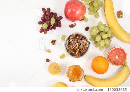 Healthy breakfast, food for children, yogurt with granola, oranges, banana and grapes on a light table. The concept of healthy and natural food, lifestyle. selective focus Healthy breakfast, food for children, yogurt with granola, oranges, banana and grapes on a light table. The concept of healthy and natural food, lifestyle. selective focus 130038685