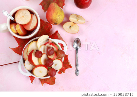 Fruit salad, healthy breakfast with ingredients, yogurt with muesli, apples, pears and grapes on a light table. The concept of healthy and natural food, lifestyle. selective focus 130038715