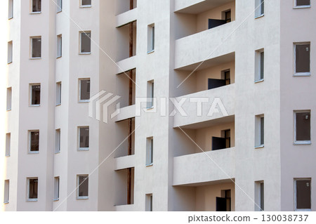 Modern residential building with balconies and large windows in a urban setting Modern residential building with balconies and large windows in a urban setting 130038737