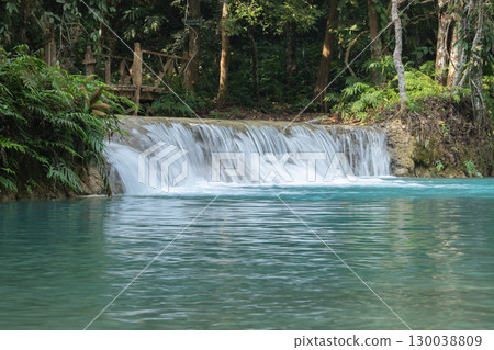 Kuang Si Waterfall flowing into a clear blue forest river in Luang Prabang, Laos Kuang Si Waterfall flowing into a clear blue forest river in Luang Prabang, Laos 130038809