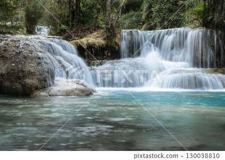 Kuang Si Waterfall flowing into a clear blue forest river in Luang Prabang, Laos Kuang Si Waterfall flowing into a clear blue forest river in Luang Prabang, Laos 130038810