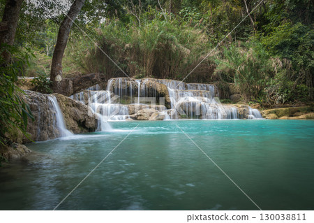 Kuang Si Waterfall flowing into a clear blue forest river in Luang Prabang, Laos Kuang Si Waterfall flowing into a clear blue forest river in Luang Prabang, Laos 130038811