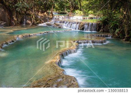 Kuang Si Waterfall flowing into a clear blue forest river in Luang Prabang, Laos Kuang Si Waterfall flowing into a clear blue forest river in Luang Prabang, Laos 130038813