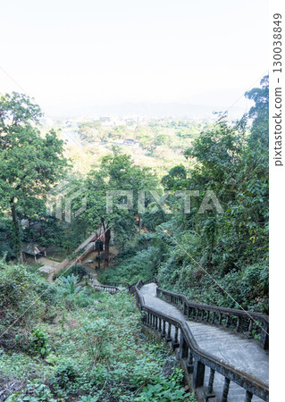 Jang Cave, Vang Vieng, Laos,Concrete staircase winding through lush forest with distant city view in Luang Prabang, Laos Jang Cave, Vang Vieng, Laos,Concrete staircase winding through lush forest with distant city view in Luang Prabang, Laos 130038849