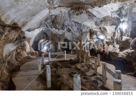 Jang Cave, Vang Vieng, Laos, Tourist exploring illuminated limestone cave with stalactites and pathway in Luang Prabang, Laos 130038853