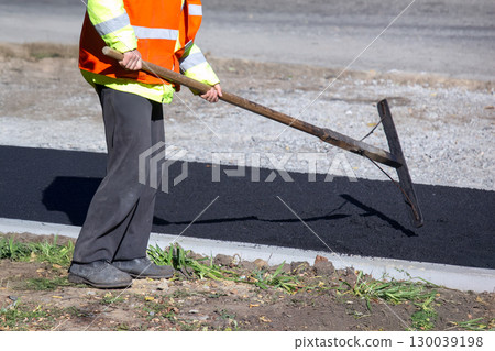 workers lay fresh asphalt on the sidewalk. road industry workers lay fresh asphalt on the sidewalk. road industry 130039198