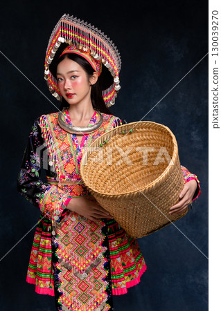 Beautiful Asian woman wearing traditional colorful ethnic costume and silver jewelry, posing in studio portrait. Cultural fashion photography showcasing vibrant embroidery, handmade textile. Beautiful Asian woman wearing traditional colorful ethnic costume and silver jewelry, posing in studio portrait. Cultural fashion photography showcasing vibrant embroidery, handmade textile. 130039270