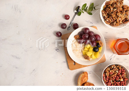 Healthy natural breakfast, food for children. Oatmeal with grapes, nuts and honey, top view, selective focus. Healthy eating concept. Healthy natural breakfast, food for children. Oatmeal with grapes, nuts and honey, top view, selective focus. Healthy eating concept. 130039318