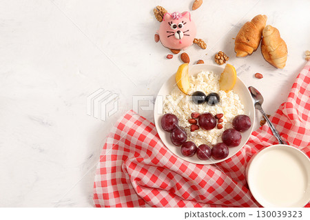 Healthy breakfast with ingredients, flat lay, fruit salad with muesli, apricots, grapes, honey and apple on a bright table. Healthy and natural food concept, lifestyle, top view, selective focus Healthy breakfast with ingredients, flat lay, fruit salad with muesli, apricots, grapes, honey and apple on a bright table. Healthy and natural food concept, lifestyle, top view, selective focus 130039323