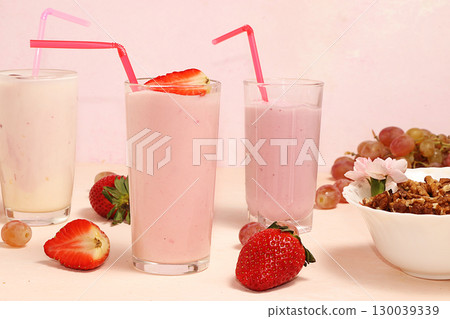 Strawberry and banana smoothies, granola, fresh berries and grapes on a pink sunny background. The concept of healthy and natural food. Useful breakfast, Strawberry and banana smoothies, granola, fresh berries and grapes on a pink sunny background. The concept of healthy and natural food. Useful breakfast, 130039339
