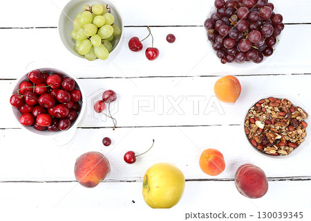 Healthy breakfast with ingredients, food for children, summer fruits and berries with granola, grapes, cherries and peaches on a bright table. The concept of a healthy and natural diet, lifestyle, 130039345