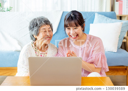 Young and senior women looking at a computer 130039389