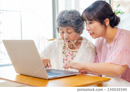 Young and senior women looking at a computer 130039390