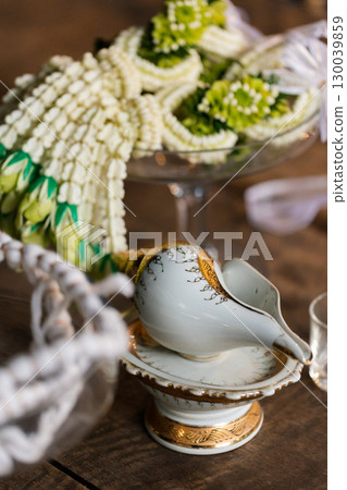 wedding concept, decorative glass bowl with beads and vintage items on wooden table 130039859