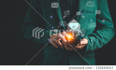 Businessman in a suit using a smartphone with floating email icons, representing digital communication, email marketing, online messaging, and modern technology in a professional environment. 130040081