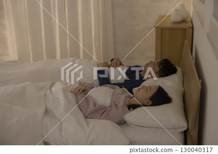 Couple sleeping in bedroom Couple sleeping in bedroom 130040317