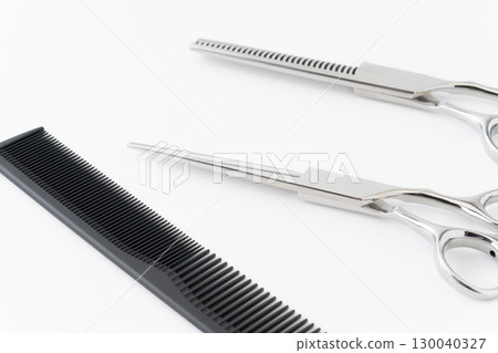 Close-up of a set of haircutting scissors, thinning shears and a comb Close-up of a set of haircutting scissors, thinning shears and a comb 130040327
