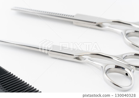 Close-up of a set of haircutting scissors, thinning shears and a comb Close-up of a set of haircutting scissors, thinning shears and a comb 130040328