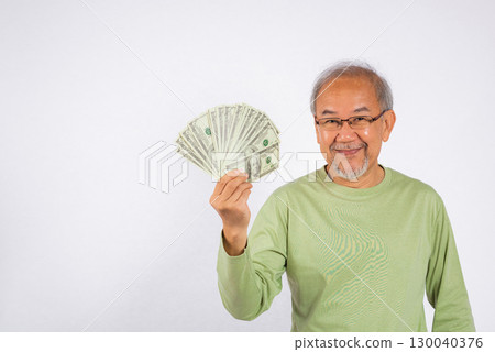 Portrait Asian smiling old man holding a bunch of money in his hand studio shot isolated on white background. Happy senior man hold money cash dollars banknotes fan 130040376