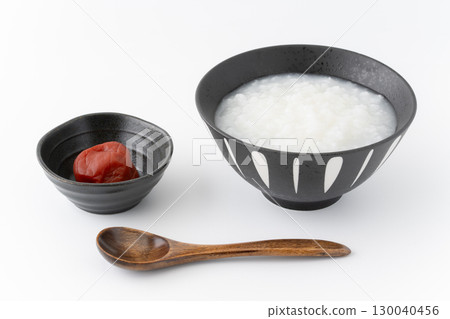 Pickled plums and rice porridge in a bowl on a white background Pickled plums and rice porridge in a bowl on a white background 130040456