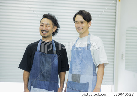 Male staff member wearing a denim apron 130040528