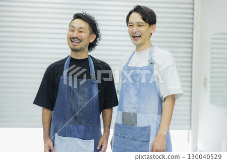 Male staff member wearing a denim apron 130040529