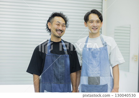 穿著牛仔圍裙的男工作人員 穿著牛仔圍裙的男工作人員 130040530